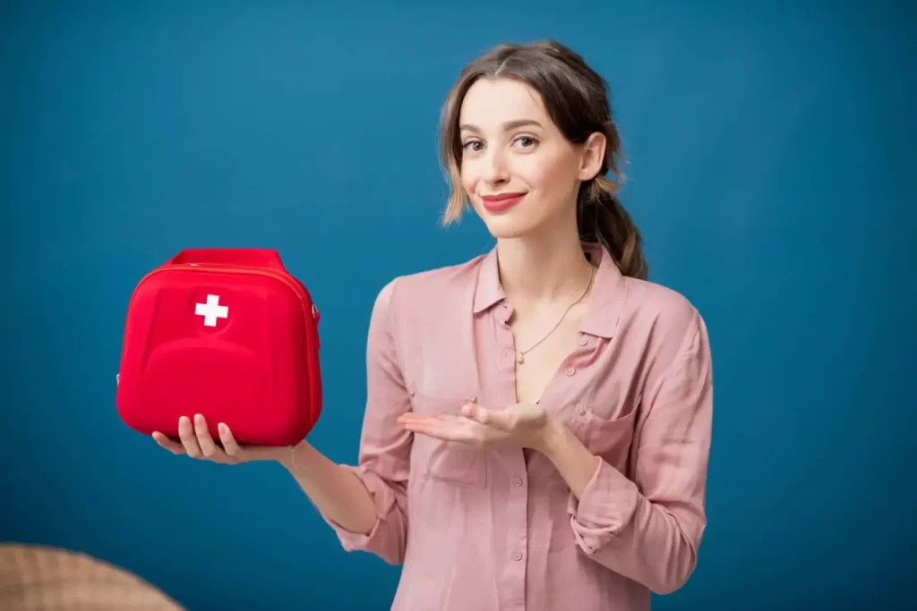 An image of a woman holding a first aid kit while receiving a free first aid consult.