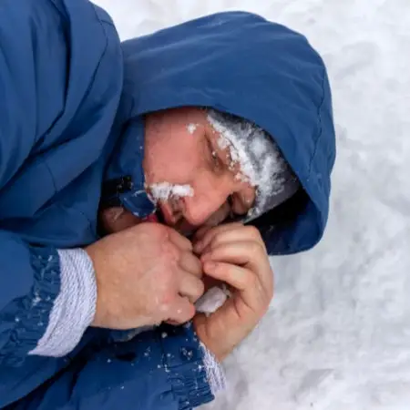 a man is suffering hypothermia and is curled up on the ground