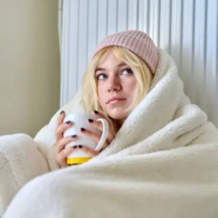 a woman warms up wrapped in a blanket