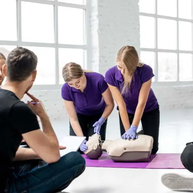 two first aid trainers demonstrate multiple rescuer cpr